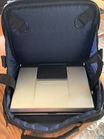 Silver Toshiba portable DVD player inside a black and blue carrying case, showing top view with Toshiba logo and control panel.