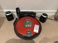 Front view of Samsung SR8830 robot vacuum with dock, remote, and two Smart Gates on carpeted floor