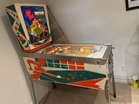 Right side view of full machine showing cabinet art, legs and playfield glass