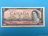 Front side of the 1954 Canadian $2 banknote showing Queen Elizabeth II and serial number with asterisk prefix indicating replacement note.