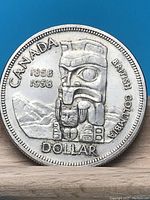 Obverse side of the 1958 Canadian silver dollar featuring a totem pole and commemorating British Columbia as a crown colony.