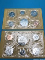 Top view of 1970 and 1971 Canadian coin sets sealed in original cellophane packaging, each containing six coins.