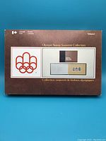 Photo of the closed brown textured box with original 1976 Olympic logo and Canada Post branding on the cover of the collection box.