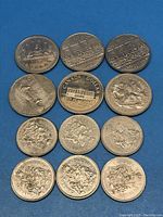 Top view of Canadian 50 cent and 1 dollar coins showing reverse side with landmarks and floral designs