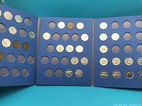 Tri-fold blue collector album with 36 slots, most filled with circulated Canadian 5 cent coins.