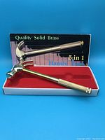 Solid brass 5 in 1 hammer in original box with red interior, handles store screwdrivers under twist-off handle end.