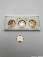 Top view of the three Canadian Centennial tokens sealed in a plastic holder, showing front sides of bronze, silver, and gold tokens with 'CANADA 1867 1967' inscription.