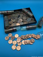 Image showing coin rolls and loose pennies spread on blue surface, mostly Canadian pennies with clear 1967 dates