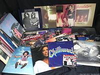 Photo showing a wide selection of vinyl record albums stacked and displayed upright with visible titles and cover art including Duran Duran, Fine Young Cannibals, Silverlode signed album, Village People, Chilliwack, Andy Gibb and others.
