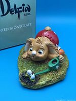 Front view of Pendelfin Alfie figurine, showing rabbit with mushroom hat and watering can on grassy base, with Pendelfin box in background