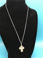 Sterling silver necklace displayed on black bust showing full length chain and cross pendant