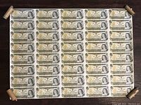 Full view of uncut sheet of 40 one-dollar bills laid flat