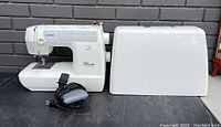 Brother Pacesetter PS-3700 sewing machine next to its carrying case with electronic foot pedal front view