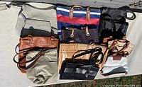 All eight purses displayed arranged on ground to show variety and condition.