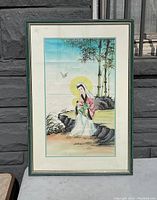 Full view of framed vintage Japanese watercolour painting showing woman and bamboo with visible signs of aging on matting.