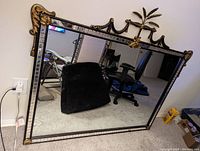Full view of large rectangular antique wall mirror leaning against wall, showing overall design and size.