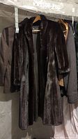 Front of the full-length black ranch mink coat showing shiny fur and full sleeves.