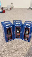 Three unopened Ron Darling bobblehead figurines for the New York Mets lined up on carpet