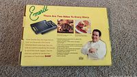 Yellow box featuring branding and images showing the reversible cast iron grill/griddle and food cooked on both sides, with photo of Emeril and usage information.