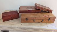 Photo showcasing five different wood boxes of various sizes and styles arranged on a table, highlighting their condition and style.