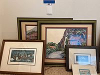 Five framed paintings against wall and carpet floor, shows their relative sizes and framing styles
