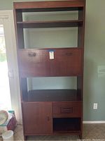 Full front view of desk showing open shelving, drop-front surface closed and lower cabinet.