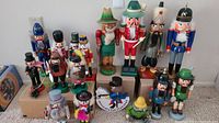 Front view of entire group of 14 wooden nutcrackers on cardboard boxes