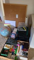 Photo showing a collection of stationary and office items including globe, bulletin board, trays with pens and markers, loose papers, greeting cards, and various desk accessories.