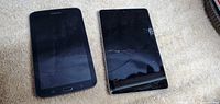 Front of two tablets, Samsung on left with visible screen, Asus Nexus on right with cracked screen protector.