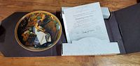 Top view of the collectible plate inside open box with Certificate of Authenticity visible.
