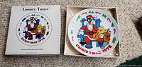 Photo showing front of Looney Tunes 1978 Christmas collector plate in original box, featuring characters and holiday design.