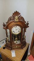 Front right view of carved wooden clock on table