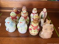 Twelve figurines arranged front to back on wooden surface