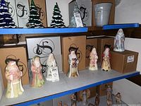 Shelf display showing six Santa figurines side by side on storage shelving