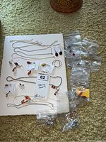 All necklaces and earrings arranged on board and floor; overview of lot contents