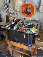 Skil-Saw 10" table saw with multiple clamps, cords, and accessories on top