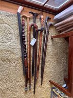 Overall shot of eight carved wooden walking canes laid out