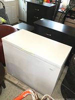 Front and side view of white chest freezer in garage