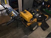 Side view of yellow Cub Cadet walk-behind mower showing handle and front tires