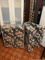 Two foam mattresses in floral fabric covers folded upright side by side, showing compact fold and thickness.