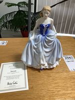 Front side view of Royal Doulton Susan figurine with certificate of authenticity visible.