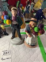 Photo of Balloon Boy and Balloon Girl Royal Doulton figurines together on a quilted white surface.