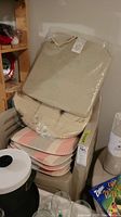 Stack of seat cushions in beige and striped patterns, some still in plastic wrapping.