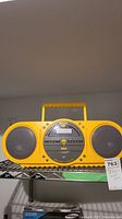 Yellow RCA boombox radio with handle, two speakers, cassette deck and control buttons.