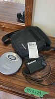 Sony CD Walkman and Macleans portable radio with black carrying case on wooden surface.