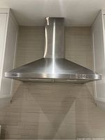 Front view of entire hood installed between cabinets