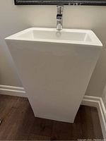 Side view of white freestanding pedestal vanity with integrated sink