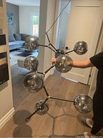 Overall view of assembled chandelier held by person showing shape and size