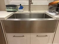 Front view of installed stainless steel apron-front sink