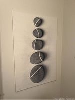 Front view of the wall art picture showing six grey stones with white lines arranged vertically on white background.